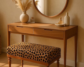 May include: A wooden vanity table with two drawers and a round mirror. A leopard print upholstered bench sits in front of the table.