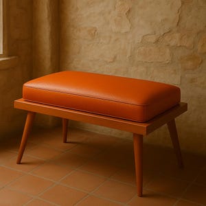 May include: A wooden bench with a bright orange leather cushion. The bench has four legs and a rectangular shape.