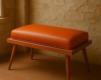 Banco de cuero naranja de mediados de siglo, hecho a mano: un asiento minimalista para la entrada.