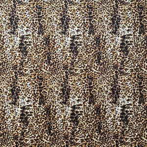 May include: A close-up of a fabric with a leopard print pattern. The pattern features a mix of brown, black, and tan spots on a cream-colored background. The spots vary in size and shape, creating a textured appearance.
