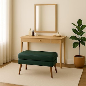 May include: A wooden vanity set with a rectangular mirror, a drawer, and a dark green bench with wooden legs. A potted plant sits to the right. The set is in a room with a neutral color palette.