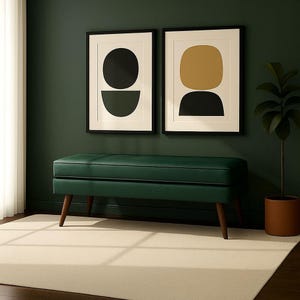 May include: A dark green bench with wooden legs sits on a light beige rug. Two framed abstract art prints hang on a dark green wall. A potted plant is on the right side of the image. The bench is a mid-century modern style.