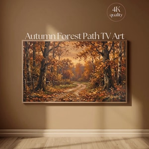 May include: A rectangular digital display showing a landscape painting titled Autumn Forest Path TV Art. The artwork depicts a winding dirt path through a dense forest with trees featuring orange and brown foliage, a wooden fence, and fallen leaves.