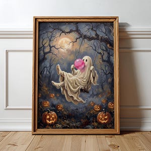 May include: A framed wall art print featuring a ghost draped in a white sheet sitting on a swing, blowing a bright pink bubble. The scene is set in a dark forest at night with a full moon and numerous glowing jack-o'-lanterns on the ground.