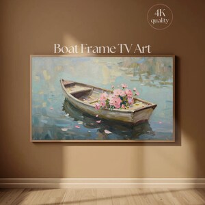 Puede incluir: Una obra de arte enmarcada representa un pequeño bote lleno de flores rosas flotando en el agua. La pintura tiene un estilo suave e impresionista con una paleta de colores apagados de azules, verdes y marrones. El texto "Boat Frame TV Art" se muestra en la parte superior.