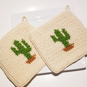 May include: Two crocheted pot holders with a cactus design. The pot holders are cream colored with green and brown cacti.