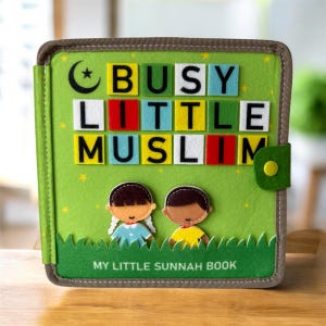 May include: A green felt book with the words "BUSY LITTLE MUSLIM" in colorful block letters. The cover features a crescent moon and star, two cartoon figures, and the text "MY LITTLE SUNNAH BOOK". The book has a green flap with a yellow button.