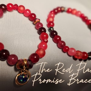 May include: Two red beaded bracelets. One bracelet has a gold charm with a blue and black stone. The bracelets are made of various shades of red beads. The text "The Red Planet Promise Bracelets" is in the image.