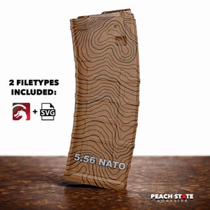 May include: A brown magazine with a topographic map design and the text "5.56 NATO". The image includes the text "2 FILETYPES INCLUDED:" with a dragon logo and an SVG icon. The Peach State Adhesive logo is in the bottom right corner.