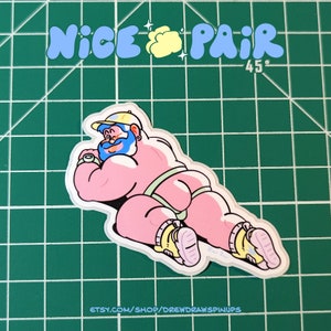 May include: A pink cartoon illustration of a muscular person wearing a blue and white baseball cap, a green and white swimsuit, and white trainers. The person is lying on their stomach with their head turned to the side. The background is a green grid.