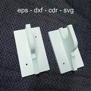 May include: Two white, 3D-printed wall-mounted holders. Each has a rectangular base with a curved top section and a handle-like projection. The text "eps - dxf - cdr - svg" is printed in white at the top.