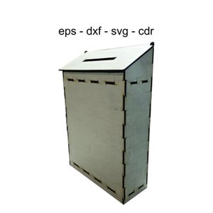 Könnte beinhalten: Eine hellfarbene Holzkiste mit schrägem Dach und einem Schlitz oben. Die Kiste hat eine rechteckige Form mit sichtbaren Schnittlinien entlang der Kanten. Der Text "eps - dxf - svg - cdr" ist über der Kiste aufgedruckt.