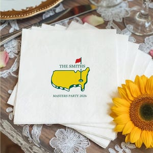 May include: White paper napkins with a green and yellow map design, a red flag, and the text "THE SMITHS" and "MASTERS PARTY 2026". A yellow sunflower is in the background.