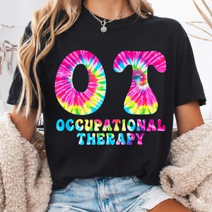May include: Black t-shirt with the letters "OT" in a tie-dye design, with the words "Occupational Therapy" in colorful bubble letters below. The shirt is a casual style.