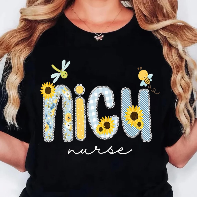 May include: Black t-shirt with the words "NICU nurse" in a whimsical design. The letters are decorated with sunflowers, blue gingham, and floral patterns, with a dragonfly and bee accents.