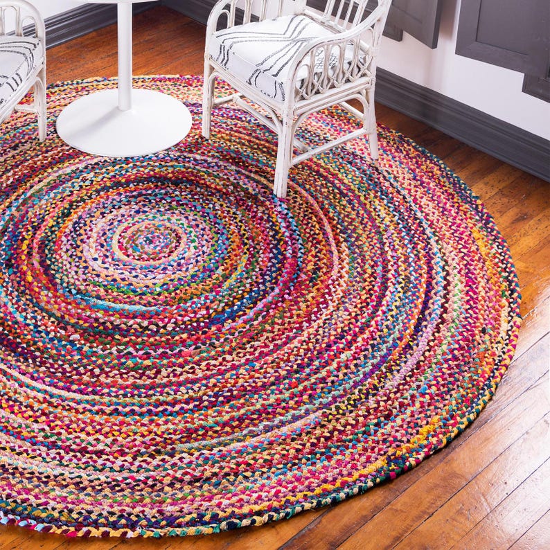 May include: A colorful round braided rug with a multi-colored pattern. The rug is made of recycled materials and has a natural, earthy look.