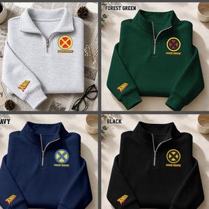 Op de afbeelding: Een collectie van zes kwart-rits sweatshirts in grijs, bosgroen, blauw, marineblauw, zwart en roze. Elk sweatshirt heeft een X-Men logo op de borst met de tekst YOUR NAME eronder en een X-Men logo geborduurd op de rechter mouwboord.
