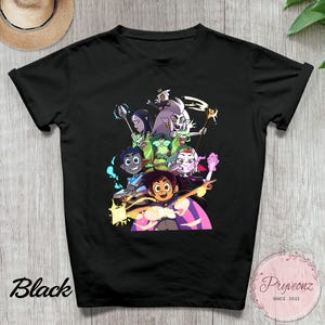 May include: Black t-shirt featuring a colorful graphic of animated characters. The design includes characters with various skin tones and hair colors, set against a background of purple and yellow. The word "Black" is printed on the lower left.