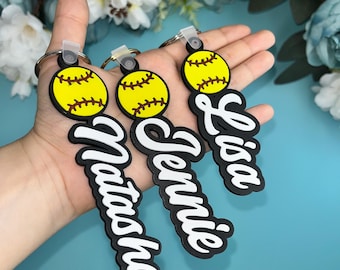 May include: Three black and white softball keychain charms with yellow softball designs. The charms are labeled "Natasha", "Jennie", and "Lisa".