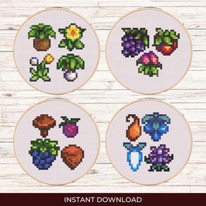 May include: Four cross-stitch patterns featuring various plants and fruits. The patterns are displayed on white fabric with a light wood background.