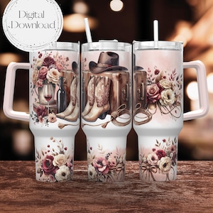 May include: A set of three stainless steel tumblers with a pink and white floral design. The tumblers feature a cowboy hat, boots, and suitcases. The tumblers have a pink lid and a pink handle.