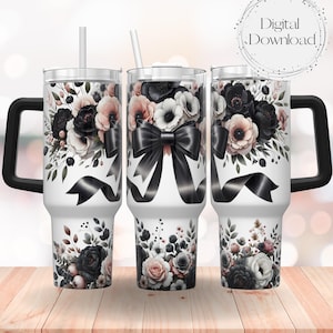 Könnte beinhalten: Ein weißer Becher mit einem schwarz-weißen Blumendesign und einer schwarzen Schleife. Der Becher hat einen Deckel und einen Griff.