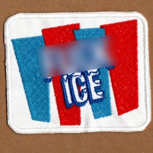 Może przedstawiać: Biały ceramiczny kubek z czarnym uchwytem i napisem "But First, Coffee" pogrubioną czcionką. Kubek jest ustawiony na rozmytym tle, sugerującym przytulne otoczenie.