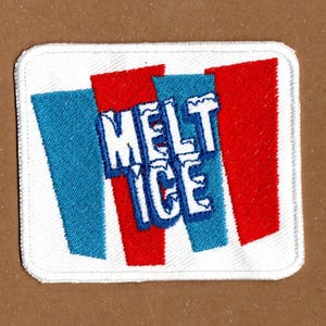 Może przedstawiać: Biały ceramiczny kubek z czarnym uchwytem i napisem "But First, Coffee" czarną, odręczną czcionką. Kubek stoi na białej powierzchni.