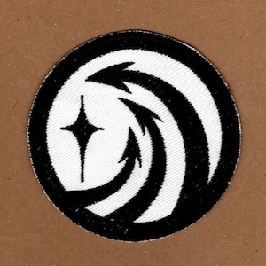 May include: White embroidered patch with a black outline. The patch features a stylised star with three points and a curved, abstract design with three black lines.