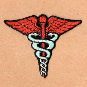 May include: Embroidered patch featuring the Caduceus symbol, a medical emblem. The design includes red wings, a black staff, and two green snakes intertwined. The patch is on a tan background.