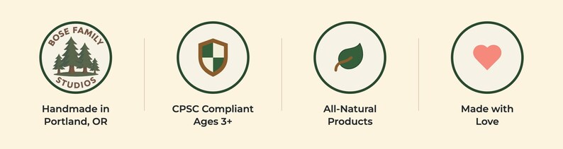 Four circular trust badges for Bose Family Studios: pine tree logo badge reading 'Handmade in Portland, OR,' green-and-cream shield icon for 'CPSC Compliant Ages 3+,' leaf icon for 'All-Natural Products,' and heart icon for 'Made with Love.'
