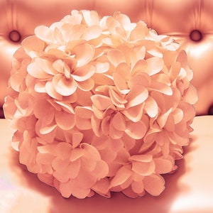 May include: A large, blush-colored flower made of fabric petals. The flower is arranged in a round shape and has a soft, delicate appearance.