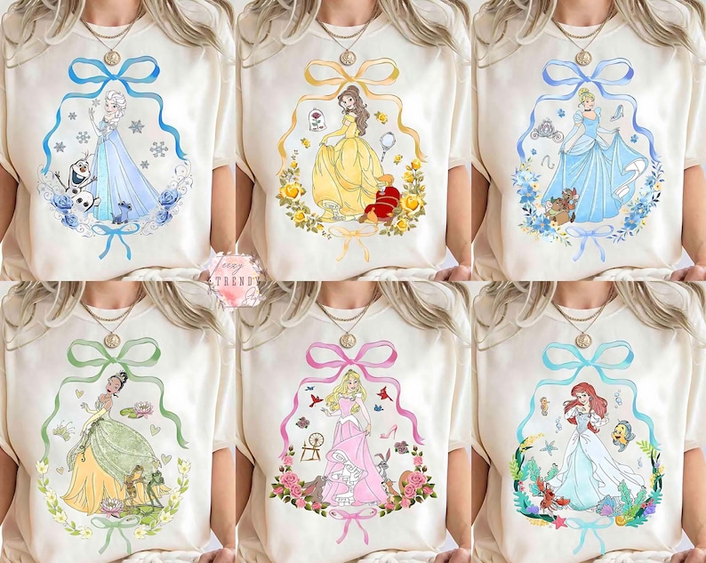 Peut inclure: T-shirts blanc cass&eacute; avec des illustrations &agrave; l'aquarelle de princesses Disney. Chaque t-shirt pr&eacute;sente une princesse diff&eacute;rente dans un cadre d&eacute;coratif avec un n&oelig;ud en haut. Les princesses sont Elsa, Belle, Cendrillon, Tiana, Aurore et Ariel.