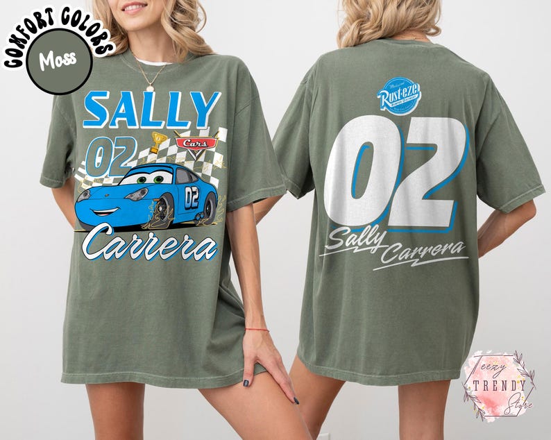 May include: Moss green t-shirt featuring a blue race car graphic with the text "SALLY 02 Carrera" on the front. The back of the shirt displays a large "02" and "Sally Carrera" text. The shirt has a relaxed fit.