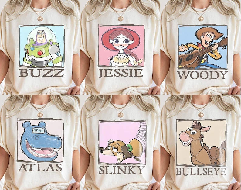May include: Cream-coloured t-shirts with cartoon character portraits in rectangular frames. Characters include Buzz Lightyear, Jessie, Woody, Atlas, Slinky, and Bullseye, each with their name below. The designs are in a cartoon style.