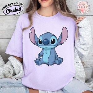 May include: A white ceramic mug with a black handle and the text "But First, Coffee" in a black, bold font. The mug is on a white surface.