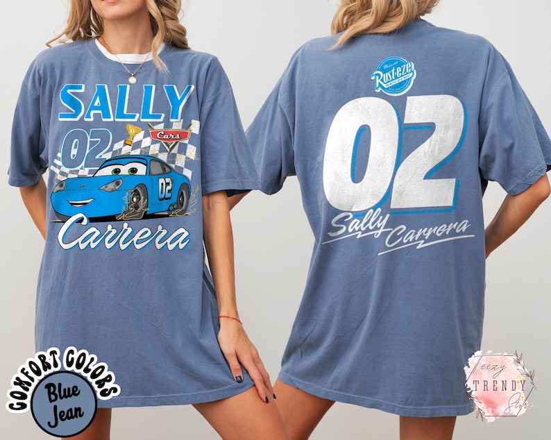 May include: A blue jean-colored t-shirt featuring the character Sally Carrera from the movie Cars. The front graphic includes the text "SALLY 02 Carrera" with a cartoon image of the car. The back of the shirt displays "02 Sally Carrera".