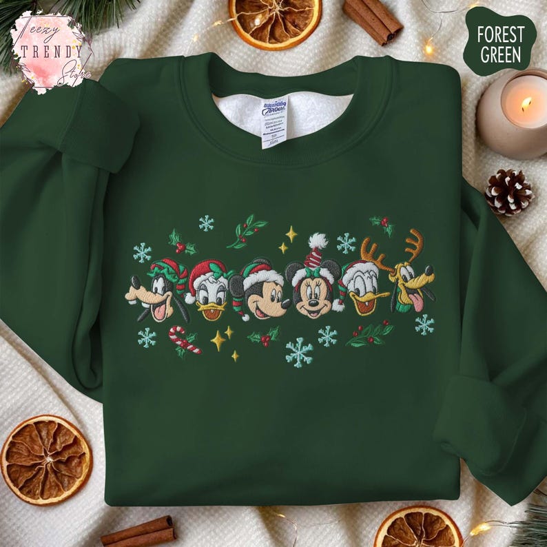 May include: Forest green sweatshirt with embroidered cartoon characters wearing Santa hats and festive accents. The design includes Goofy, Donald Duck, Mickey Mouse, Minnie Mouse, and Pluto. The sweatshirt has a crew neck and long sleeves.