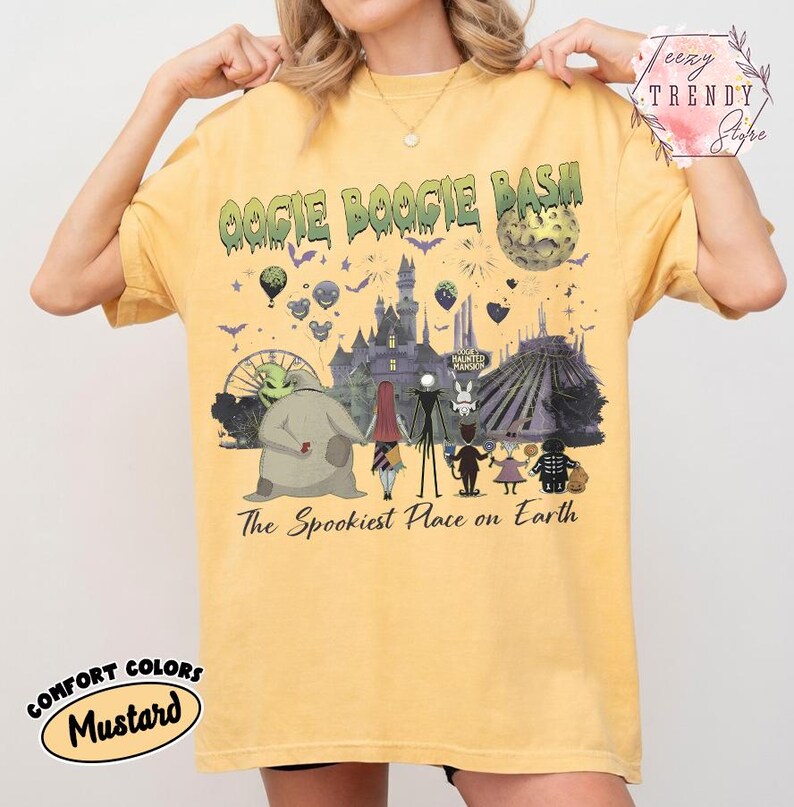 May include: A mustard yellow short-sleeve t-shirt featuring a graphic print with the text OOGIE BOOGIE BASH and The Spookiest Place on Earth. The design includes a castle, a moon, and various characters from The Nightmare Before Christmas.