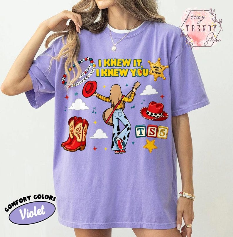 May include: A violet t-shirt featuring a graphic print with the text I KNEW IT, I KNEW YOU, a cartoon character playing a guitar, red cowboy boots, a red hat, a sheriff star badge, and colourful blocks with the letters TS5 on a light background.
