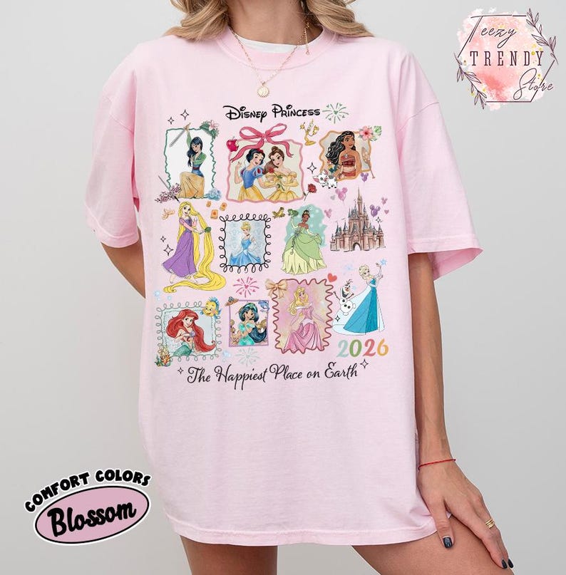 May include: A light pink t-shirt featuring Disney Princesses in framed illustrations. The shirt has the text "Disney Princess" at the top and "The Happiest Place on Earth" at the bottom, with the year "2026". The shirt is made of Comfort Colors Blossom fabric.