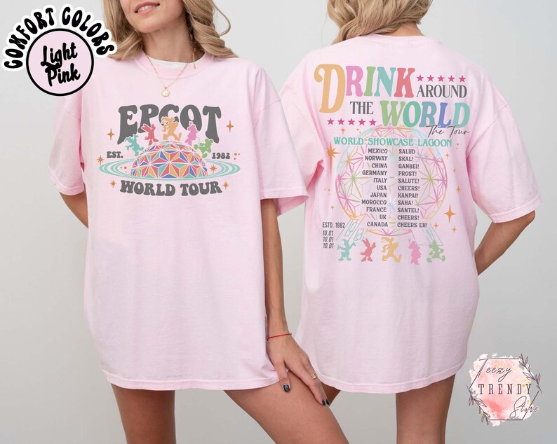 May include: Light pink t-shirt with "EPCOT World Tour" graphic on the front and "Drink Around The World" design on the back. The front graphic features a colorful geometric sphere and characters. The back design lists countries.