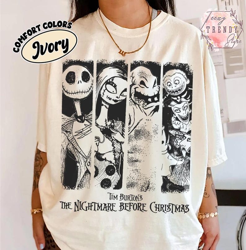 May include: An ivory short-sleeve t-shirt featuring a black graphic print of characters from Tim Burton's The Nightmare Before Christmas. The design includes four vertical panels showing Jack Skellington, Sally, Oogie Boogie, and Lock, Shock, and Barrel.