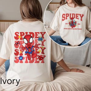 Puede incluir: Camiseta color marfil con un gr&aacute;fico de Spidey. La parte delantera muestra "SPIDEY" en rojo, con un personaje de dibujos animados de Spider-Man. La parte trasera de la camiseta tiene el texto "SPIDEY" y un gr&aacute;fico de Spider-Man.