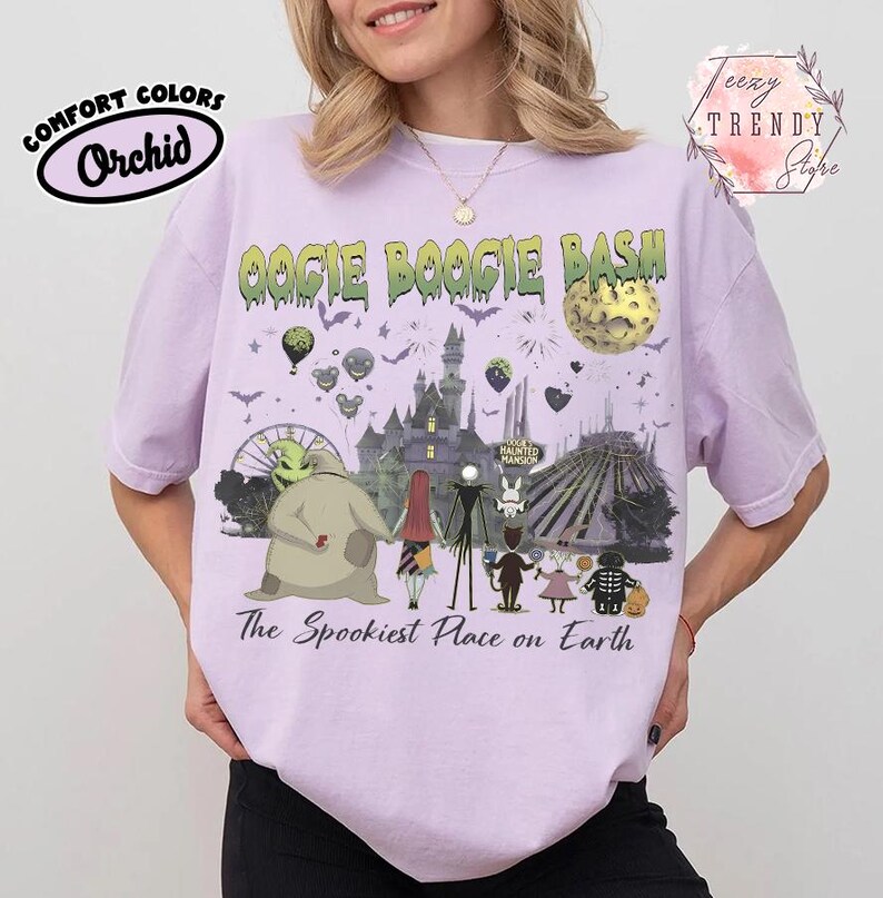 May include: A light purple t-shirt featuring a graphic print with the text OOGIE BOOGIE BASH and The Spookiest Place on Earth. The design includes characters from The Nightmare Before Christmas, a castle, a moon, and various park attractions.