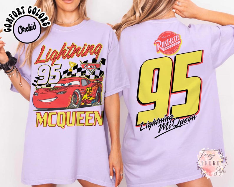 May include: Light purple t-shirt featuring a graphic of Lightning McQueen from the Cars movie. The front design includes the number 95, the character's name, and a checkered flag. The back displays a large yellow 95 and the Lightning McQueen logo.