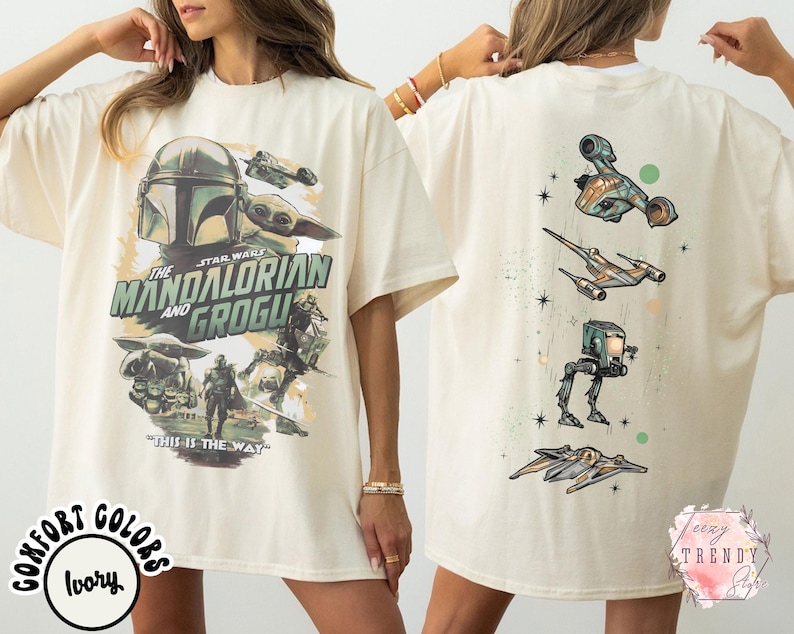 K&ouml;nnte beinhalten: Ein elfenbeinfarbenes T-Shirt mit einem Star Wars-Motiv. Die Vorderseite zeigt den Mandalorianer und Grogu mit dem Text "The Mandalorian and Grogu" und "This is the way". Die R&uuml;ckseite zeigt vier verschiedene Star Wars-Raumschiffe.
