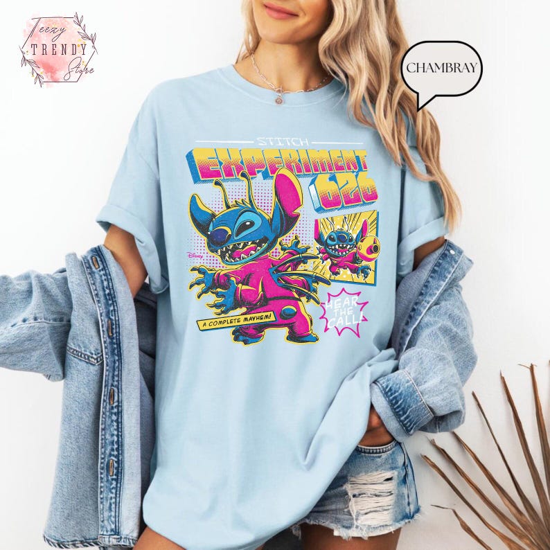 Pode incluir: Camiseta azul clara com um gr&aacute;fico colorido de Stitch de Lilo & Stitch da Disney. O gr&aacute;fico inclui o texto "Stitch Experiment 626" e "A Complete Mayhem!" em um estilo retr&ocirc;. A camiseta tem mangas curtas e um corte folgado.