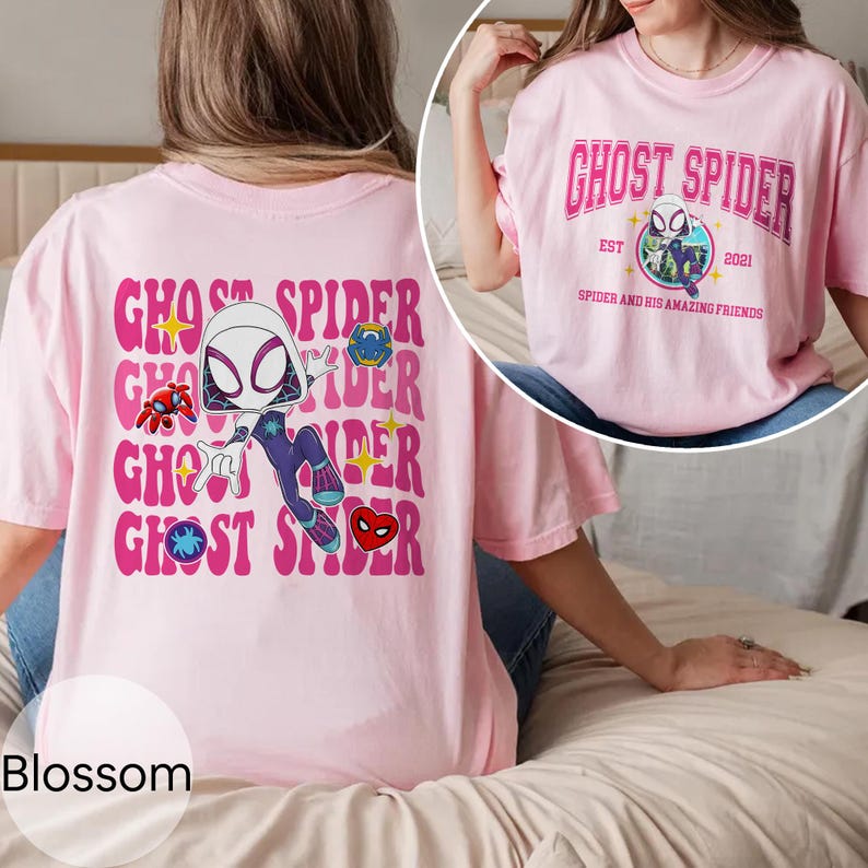 Puede incluir: Una camiseta rosa claro con el texto "GHOST SPIDER" en un dise&ntilde;o apilado y una ilustraci&oacute;n de dibujos animados de un personaje con tem&aacute;tica de ara&ntilde;a. La parte posterior de la camiseta tiene el mismo dise&ntilde;o. La parte delantera de la camiseta tiene el texto "GHOST SPIDER" con el texto "EST 2021" y "SPIDER AND HIS AMAZING FRIENDS".