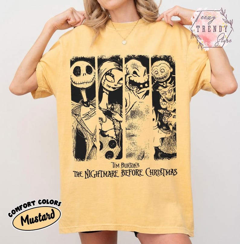 May include: A mustard yellow short-sleeve t-shirt featuring a black graphic print of characters from Tim Burton's The Nightmare Before Christmas. The design includes four vertical panels showing Jack Skellington, Sally, Oogie Boogie, and Lock, Shock, and Barrel.
